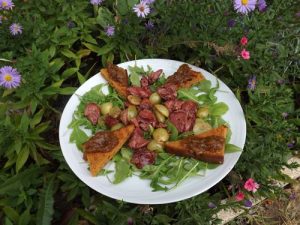 <strong>Salade de roquette, foies de volailles, croûtons de pain d'épices, confiture d'oignons et raisins frais</strong>